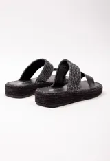 Sandalia con doble tira en el empeine, una de cuero color tostado y otra tejida en rafia. Plataforma de yute de 3.5 cm de alto.