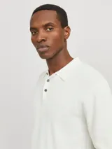 Polo de manga corta confeccionado en tejido de punto estructurado con textura sutil. Presenta cuello clásico, cierre frontal con tres botones y terminaciones en rib en mangas y ruedo.