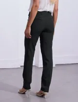 Pantalón sastrero de corte slim, color blanco, con pretina anatómica y panel interno modelador. Presenta bolsillos laterales tipo ojal, bolsillos traseros simulados y nervadura vertical marcada en el frente.