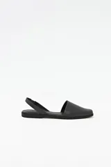 Zapato destalonado de cuero color negro, con punta cuadrada y diseño minimalista.