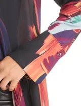 Túnica larga de gasa con estampado abstracto multicolor sobre base negra, cuello a la base, cierre frontal con botones y mangas largas con puños amplios.