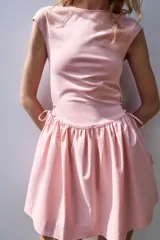 Vestido corto negro confeccionado en 100% algodón, de cuello redondo y mangas cortas. Presenta detalle de lazadas en los laterales de la cintura y falda con vuelo.