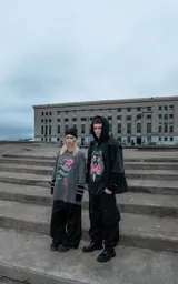 Remera de algodón color gris oscuro con efecto lavado, de corte holgado y manga corta. Presenta una estampa frontal detallada que muestra una serpiente entrelazada alrededor de una paleta de madera con corazones, rodeada por un diseño de alambre de púas.