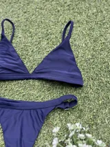 Conjunto de bikini azul con corpiño triangular fijo y bombacha colaless regulable.