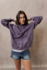 Canguro oversize fucsia con efecto washed, capucha con cordones ajustables al tono, bolsillo frontal tipo canguro y terminaciones de rib en puños y cintura.