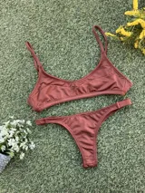 Conjunto de bikini color chocolate confeccionado en tela morley texturada. El top es tipo deportivo con breteles finos y el corpiño cuenta con aberturas para tazas soft. La bombacha es de corte colaless.