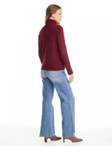 Polera de cuello alto confeccionada en tejido de punto fino, con mangas largas y detalle de tajo en los puños.