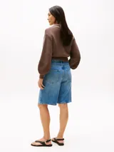 Pantalón corto de jean celeste, de corte recto y tiro medio. Con diseño de cinco bolsillos, cierre de cremallera y botón, y parche de logo Tommy Hilfiger en la parte posterior de la cintura.