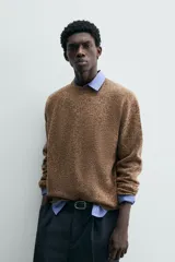 Jersey de punto de lana con textura jaspeada, corte regular fit, cuello redondo y mangas largas con puños y ruedo en rib.