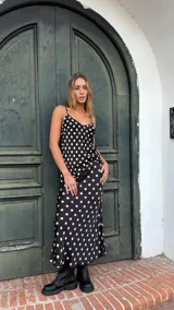 Falda midi de satén negro con estampado de lunares blancos, con abertura lateral.