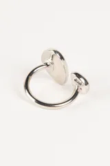 Anillo plateado con diseño moderno y minimalista, con dos esferas irregulares en los extremos.