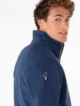 Campera de micropolar azul marino con cierre frontal, cuello alto y logo bordado en el pecho.