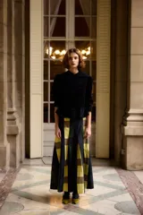 Falda larga de corte evasé con diseño de cuadros grandes en tonos amarillo, verde y azul marino. Presenta un estilo estructurado con pliegues que le otorgan volumen.