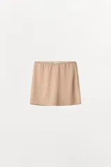 Falda mini de tiro bajo con cintura elástica, confeccionada en tejido ligero y fluido.