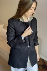 Blazer azul de lino con corte entallado, cuello y solapas combinadas en color gris, cierre con botón de nácar, bolsillos laterales y tajo en la espalda.