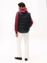 Chaleco acolchado de nailon reciclado, color azul marino, con cuello alto y cierre frontal de cremallera. Presenta el logo de Tommy Hilfiger bordado en el pecho.