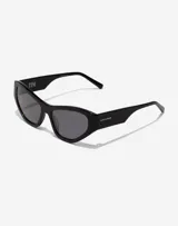 Lentes de sol Hawkers x Tini modelo Code, con armazón de acetato negro y diseño cat-eye. Presentan cristales oscuros y detalles de marca grabados en las patillas.