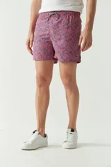 Short de baño con estampado botánico en tonos azules y rosados, con cintura elástica ajustable mediante cordón, bolsillos laterales y bolsillo trasero.