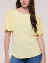 Blusa blanca de silueta suelta con escote redondo y mangas cortas estilo mariposa confeccionadas en tela plisada translúcida.