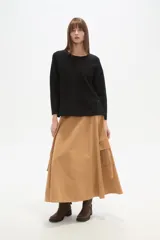 Sweater negro liso, holgado, con cuello a la base y broches decorativos en el lateral.