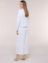 Camperita liviana de corte recto y acabado crepé color blanco, con cuello camisero clásico y cierre frontal de botones metálicos dorados. Presenta bolsillos en el pecho con solapa y mangas largas con puños abotonados.