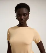 Blusa básica de cuello redondo y manga corta con detalle de dobladillo plegado. Confeccionada en tejido de viscosa con spandex, ofrece un ajuste cómodo y versátil.