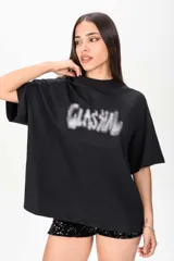 Remerón negro de corte oversize y mangas cortas, con estampa frontal difuminada estilo grafiti adornada con apliques de strass.