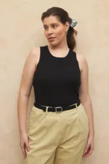 Top sin mangas color negro, de tejido acanalado y corte ajustado al cuerpo, con cuello redondo a la base.