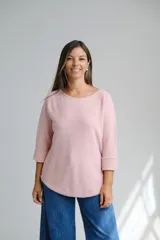 Sweater de punto color rosa pastel, con escote redondo a la base y mangas tres cuartos con dobladillo en los puños. Presenta un corte holgado y ruedo redondeado.