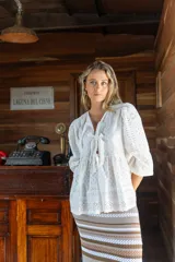 Camisa amarilla de broderie con escote en V, mangas globo y lazos ajustables en el frente.