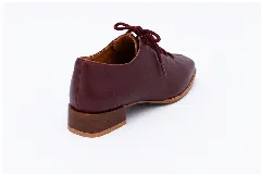 Zapatos acordonados de cuero color negro, con diseño de punta cuadrada, costuras centrales decorativas y suela marrón con taco bajo.