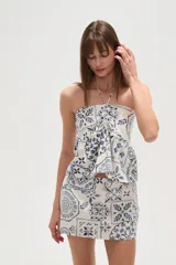 Top strapless de viscosa con estampado de azulejos en tonos azul y blanco. Presenta un diseño con cuello halter, detalle de fruncido central y un lazo decorativo en el frente.