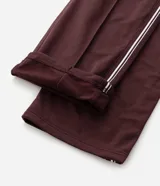 Pantalón deportivo color bordó con rayas blancas laterales, cintura elástica con cordón ajustable, bolsillos laterales y logo pequeño en el muslo.