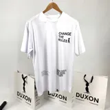 Remera blanca de algodón con estampa en el frente con la frase "CHANGE THE RULES" y un dibujo de una persona. En la parte inferior tiene otra estampa con texto ilegible.