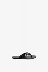 Sandalias de cuero vacuno color negro, tipo chinela, con tira de dedo y aplicación metálica con el logo de la marca en forma de 'C'.