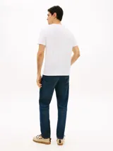 Remera Tommy Hilfiger de punto confeccionada en puro algodón, con cuello redondo y corte regular. Presenta un estampado con el logo de la marca y detalles distintivos en el pecho, además de un pequeño logo bordado en la manga.