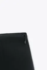 Shorts negros de tiro alto, corte recto y holgado, con cierre lateral oculto en la costura.