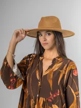 Sombrero de gamuza color tostado, estilo cowboy, con ala ancha y detalle de trenzado en la base de la copa.