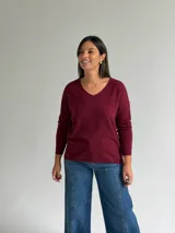 Sweater de punto en color bordó, con escote en V, mangas largas y diseño de corte recto con dobladillo ligeramente más largo en la parte posterior.
