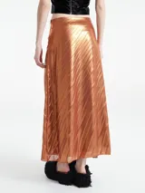 Falda larga plisada metalizada color gris oscuro, de corte evasé y cintura alta.