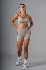 Top deportivo color beige con breteles finos cruzados en la espalda.