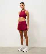 Short runner deportivo 2x1 de microfibra color bordó, con cintura elástica, bolsillo funcional con cierre y bajo redondeado.