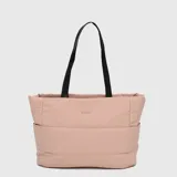 Tote bag de diseño acolchado en color rosado, con asas largas en color negro. Cuenta con compartimento interno para laptop y bolsillo trasero con cierre para sujetar a maletas.