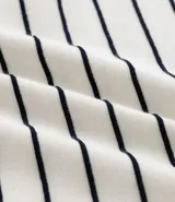 Remera de corte regular confeccionada en tejido de algodón y poliéster, con cuello redondo y mangas cortas. Presenta un diseño de rayas horizontales finas en relieve.