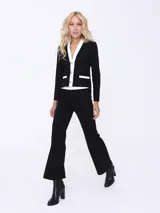 Conjunto de dos piezas compuesto por un saco entallado de manga larga con cierre frontal de botones y solapas en contraste blanco, y un pantalón de corte recto y tiro alto.