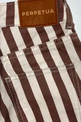 Pantalón de jean con estampado de rayas verticales marrones y blancas, de corte wide leg y tiro medio.