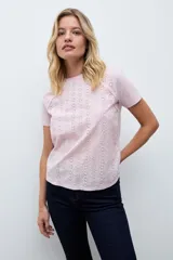 Remera de manga corta con frente confeccionado en tela broderie blanca con diseño calado y espalda de algodón liso.