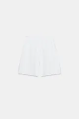 Bermuda de algodón color negro, con tiro medio, cintura elástica ajustable con cordones y bolsillos laterales ocultos en la costura.