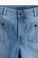 Jean ancho tobillero de denim de algodón con leve stretch, tiro alto y corte holgado. Presenta bolsillos delanteros aplicados con botón, raya marcada en las piernas y bajo con dobladillo ancho.