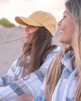 Gorro de pana color mostaza con visera y bordado frontal con la palabra "Yamba".